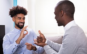 Dois homens afro-americanos se comunicando com a língua de sinais