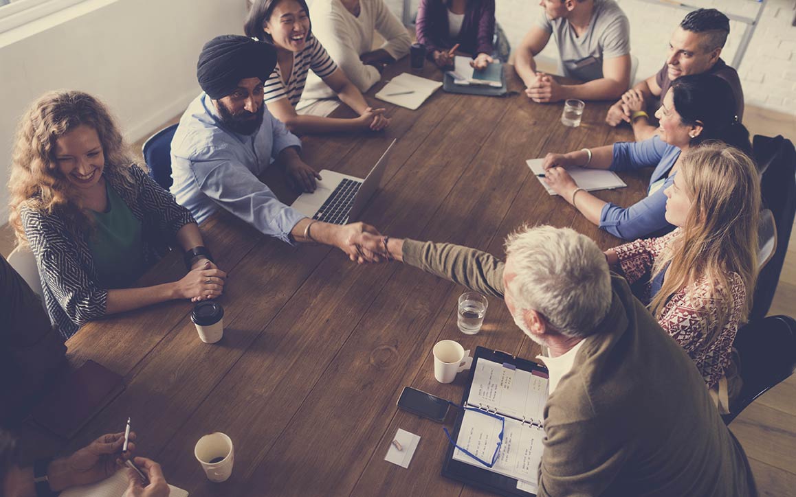Grupo de diversos funcionários em uma mesa de conferência