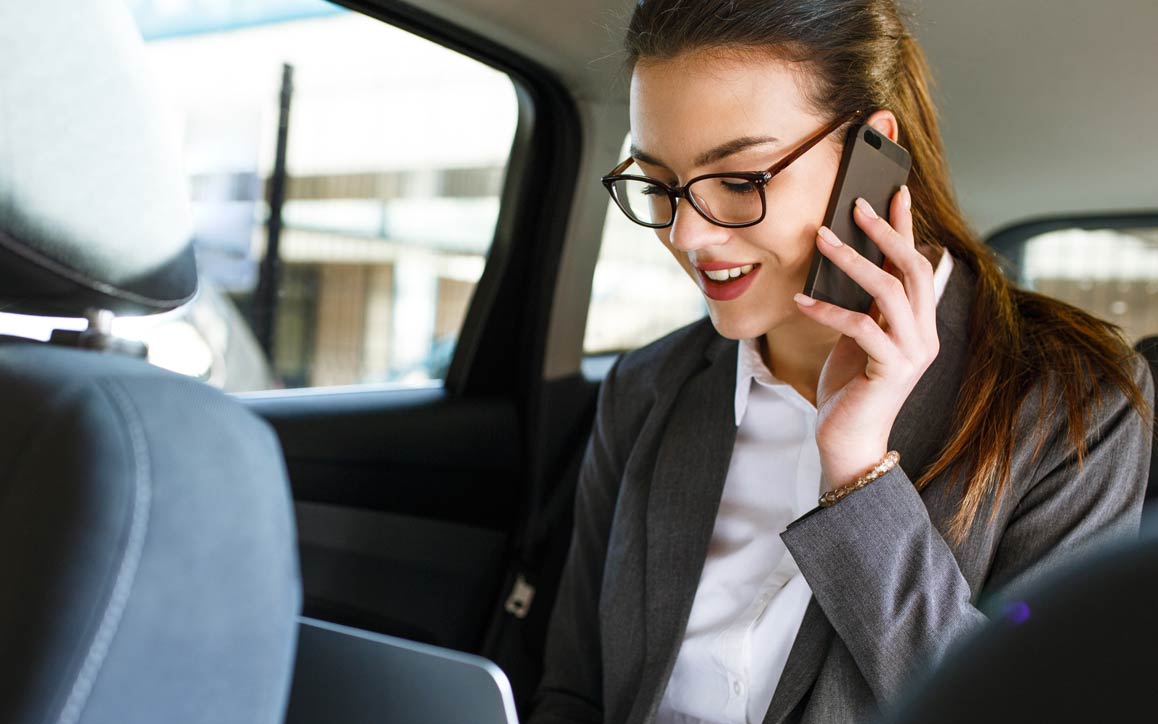 Mulher no telefone no banco traseiro do carro