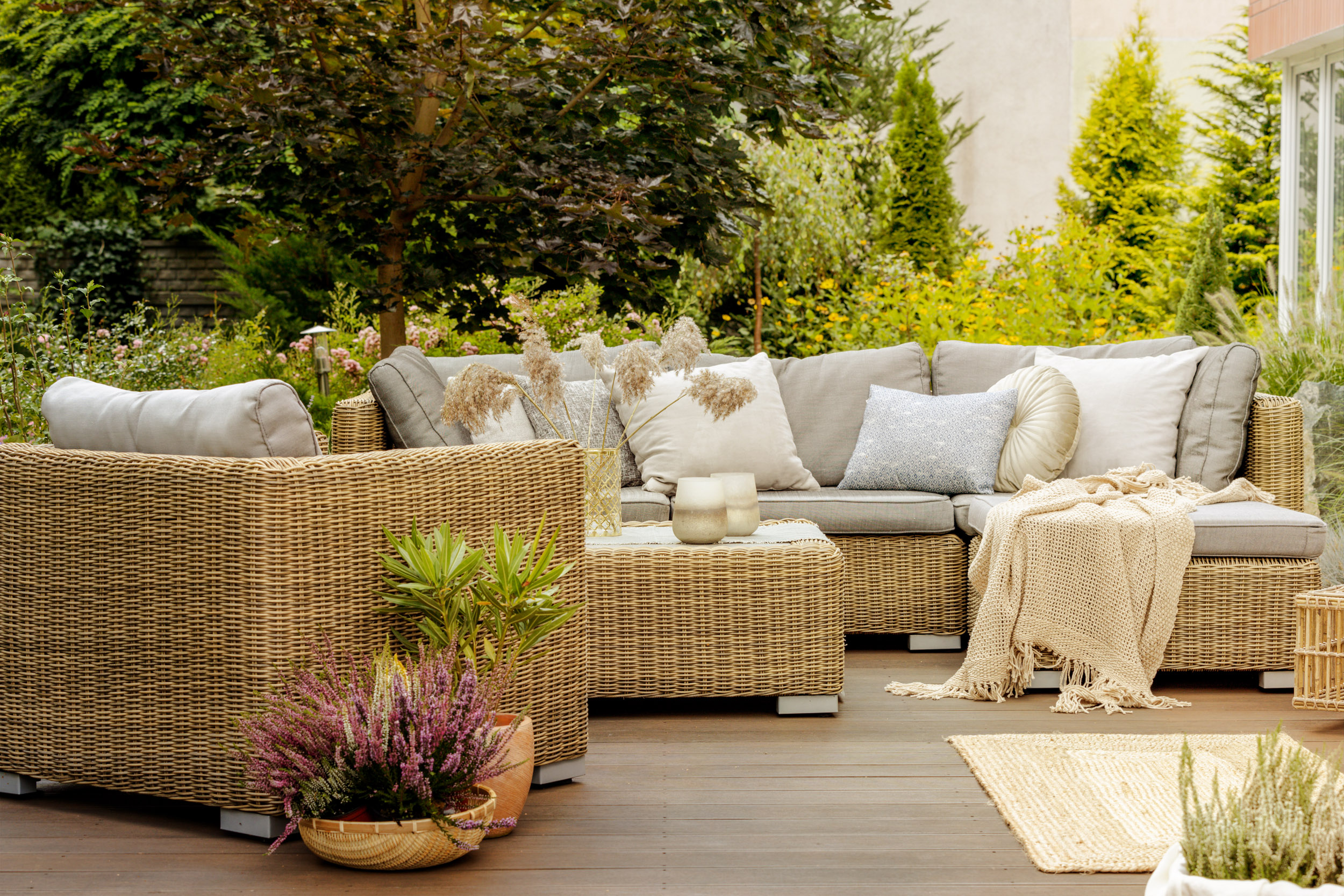 shutterstock_1524690500 Wicker furniture on a wooden terrace of modern house.
