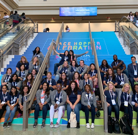 Group of women on bleachers at Grace Hopper Celebration