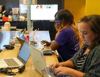 Two female ADP employees working on their laptops