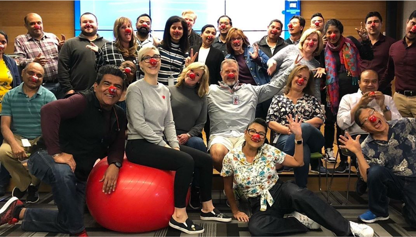 Large group of ADP employees wearing red balls on their noses