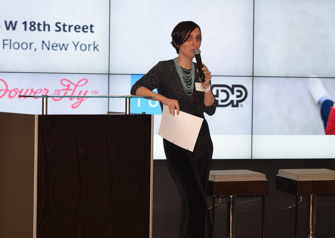 A woman holding a microphone giving a presentation