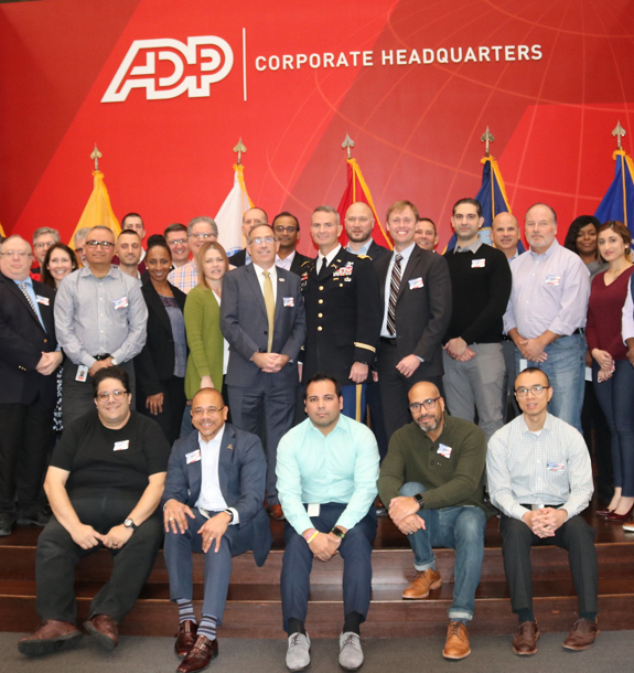 A group of ADP employees standing on a stage posed for a picture