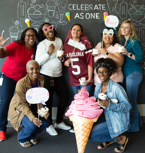 A group of ladies holding ice cream signs and cups of ice cream