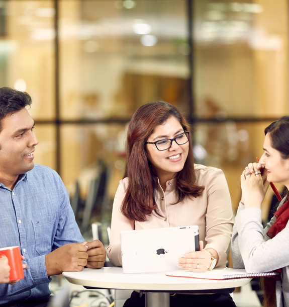 Three ADP employees sitting and talking at a small table