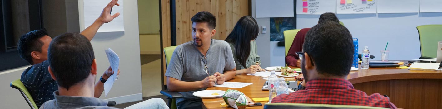 a small group of ADP employees seated around a conference table collaborating on a project