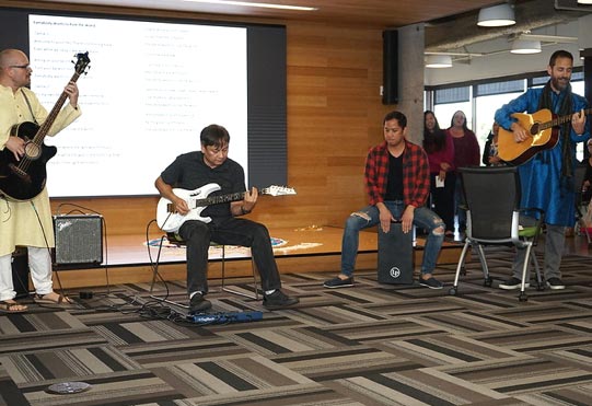 a small group of men holding various musical instruments