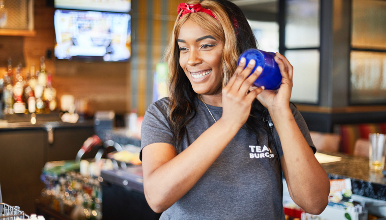 Smiling Chili’s Bartender shaking mixed drink behind bar