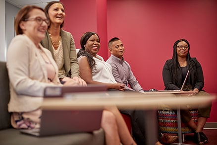 2019-diversity-whiteboard-min Grupo diverso de colaboradores assistindo a uma apresentação no escritório.
