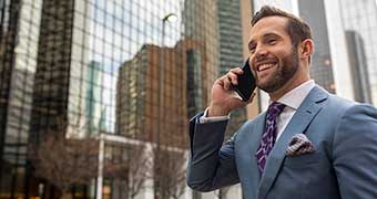 Man wearing a suit talking on cell phone on city street