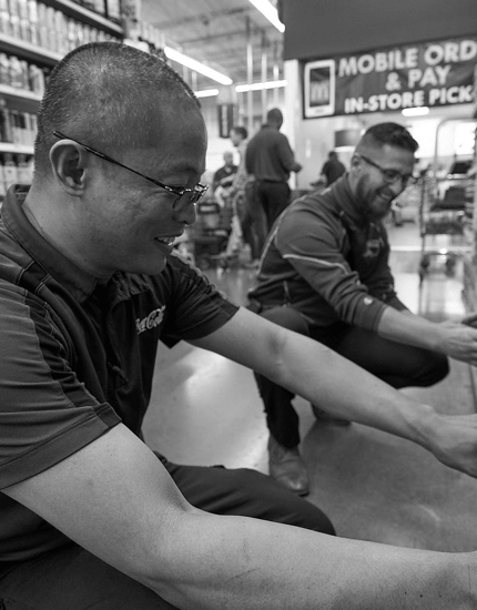 Two Reyes Holdings team members sorting and storing Reyes Coca-Cola products on shelves.
