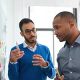 Three people discussing post-it notes on a whiteboard