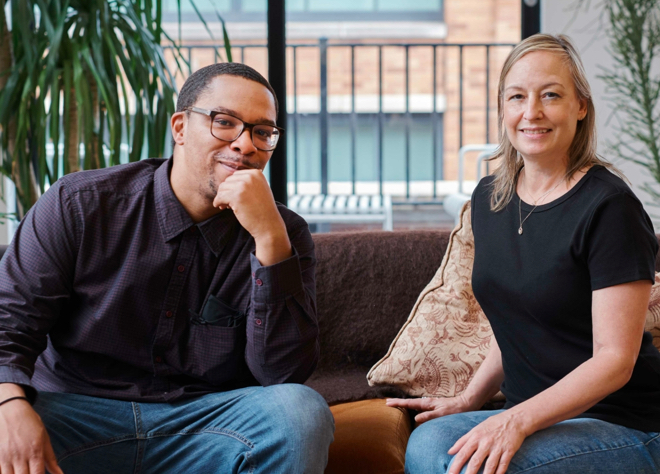A man and a woman sitting and smiling at the camera