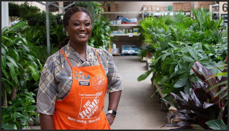 An Assistant Store Manager smiles into the camera inside a indoor garden center.