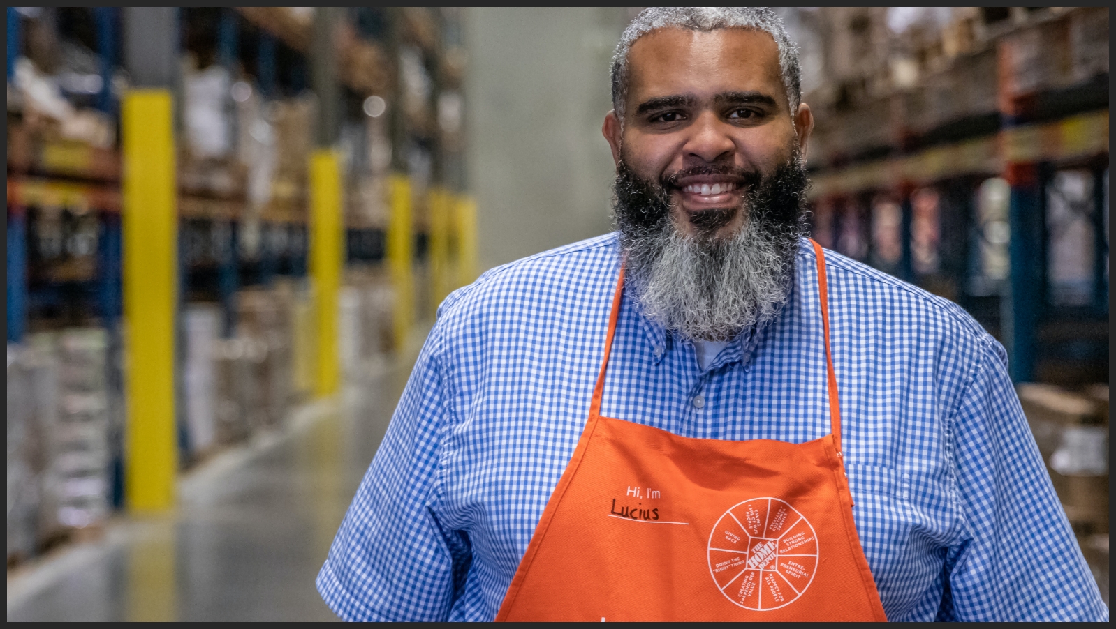 An Assistant General Manager smiles into the camera inside a distribution center.