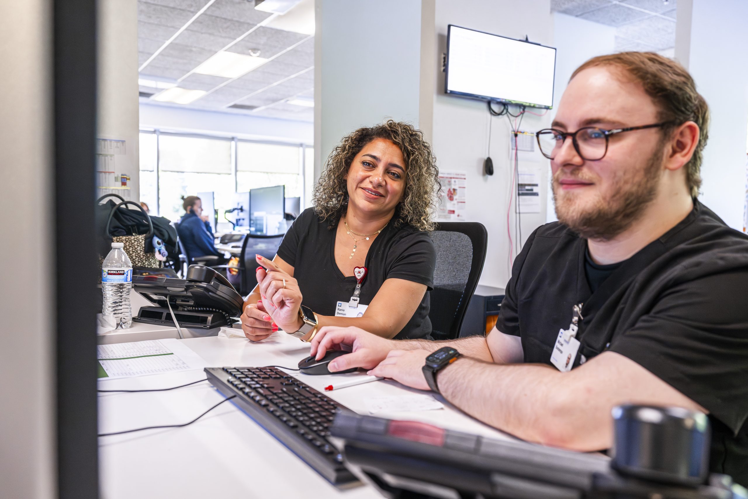 Two Cleveland Clinic healthcare staff working together at a computer desk.