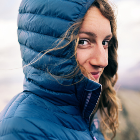 smiling woman wearing coat in chilly outdoor setting