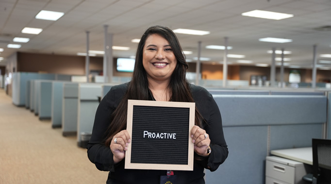 Woman holding a sign saying Proactive