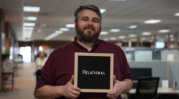 Man holding sign saying Relational