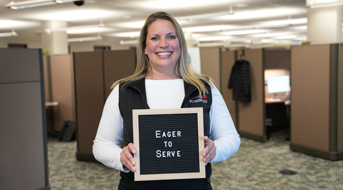 Woman holding sign saying Eager to Serve