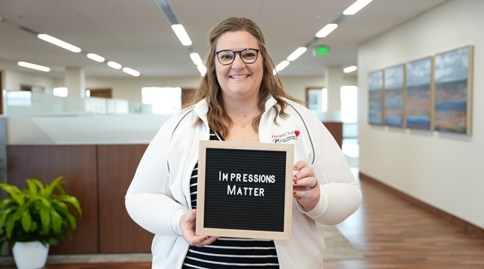 Woman holding sign saying Impressions Matter