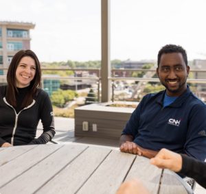Four CNH Internal Audit employees sit around a table and work together.