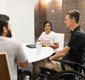 Three CNH Human Resources employees stand around and talk casually together.