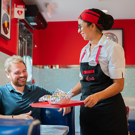 mels crop Woman giving a man a tray of food