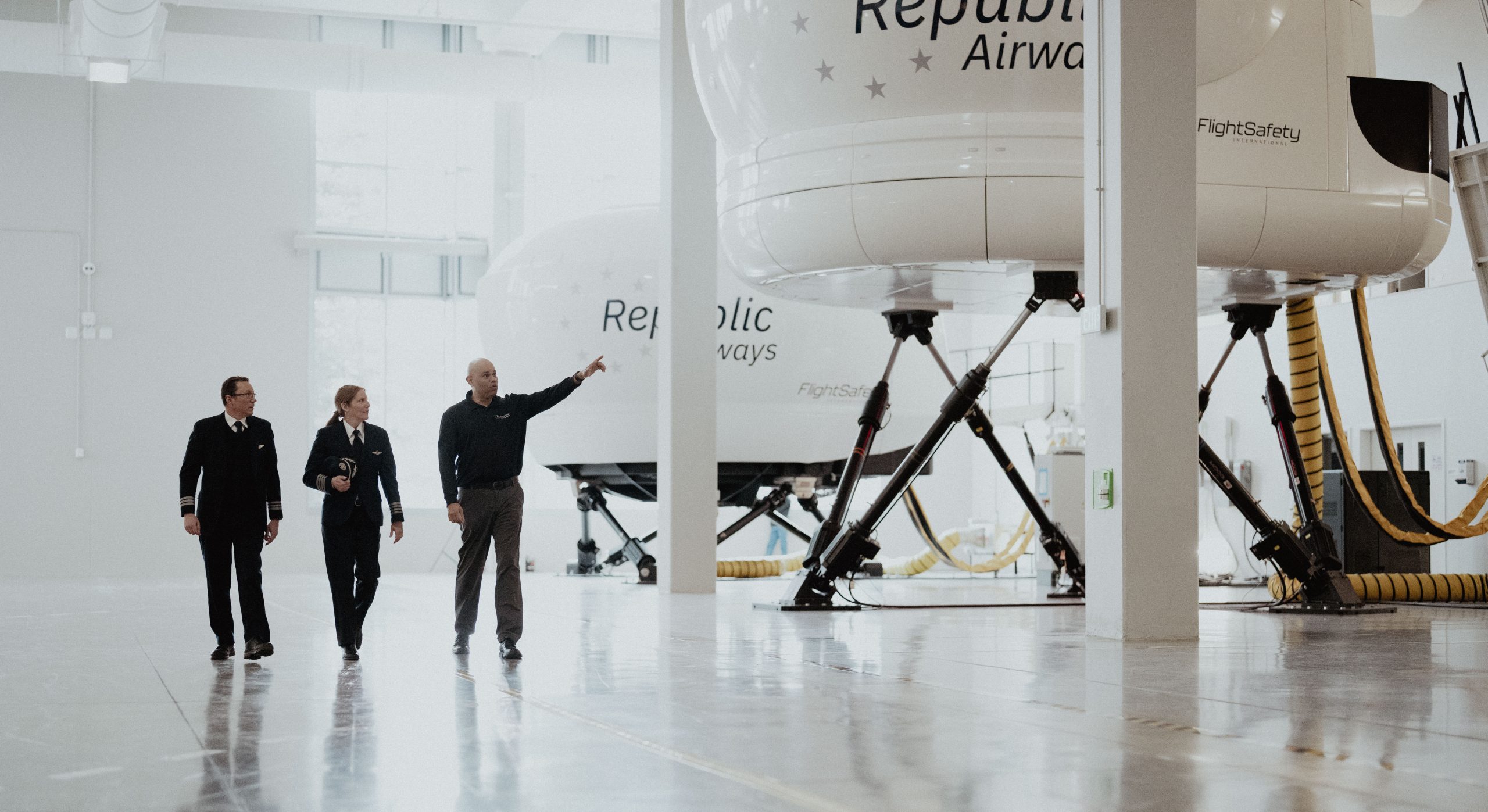A group of pilots, one laughing in front of aircraft.