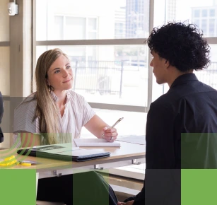Female corporate recruiter speaking with male high school student