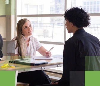 Female corporate recruiter speaking with male high school student