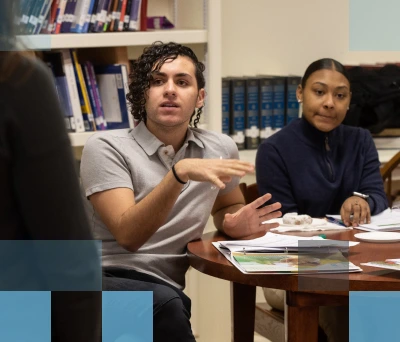 A diverse group of students having a discussion at a table in a library