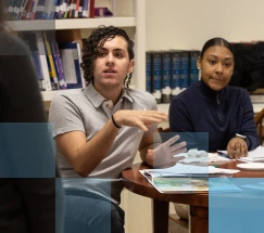 A diverse group of students having a discussion at a table in a library