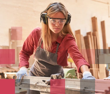 Female high school student working at a large table saw