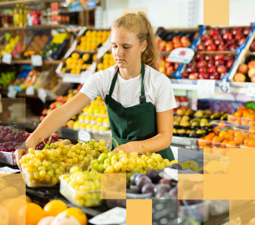 A female high school graduate working in the produce section of a market