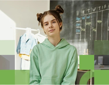 A confident female high school student standing in front of a chalk board