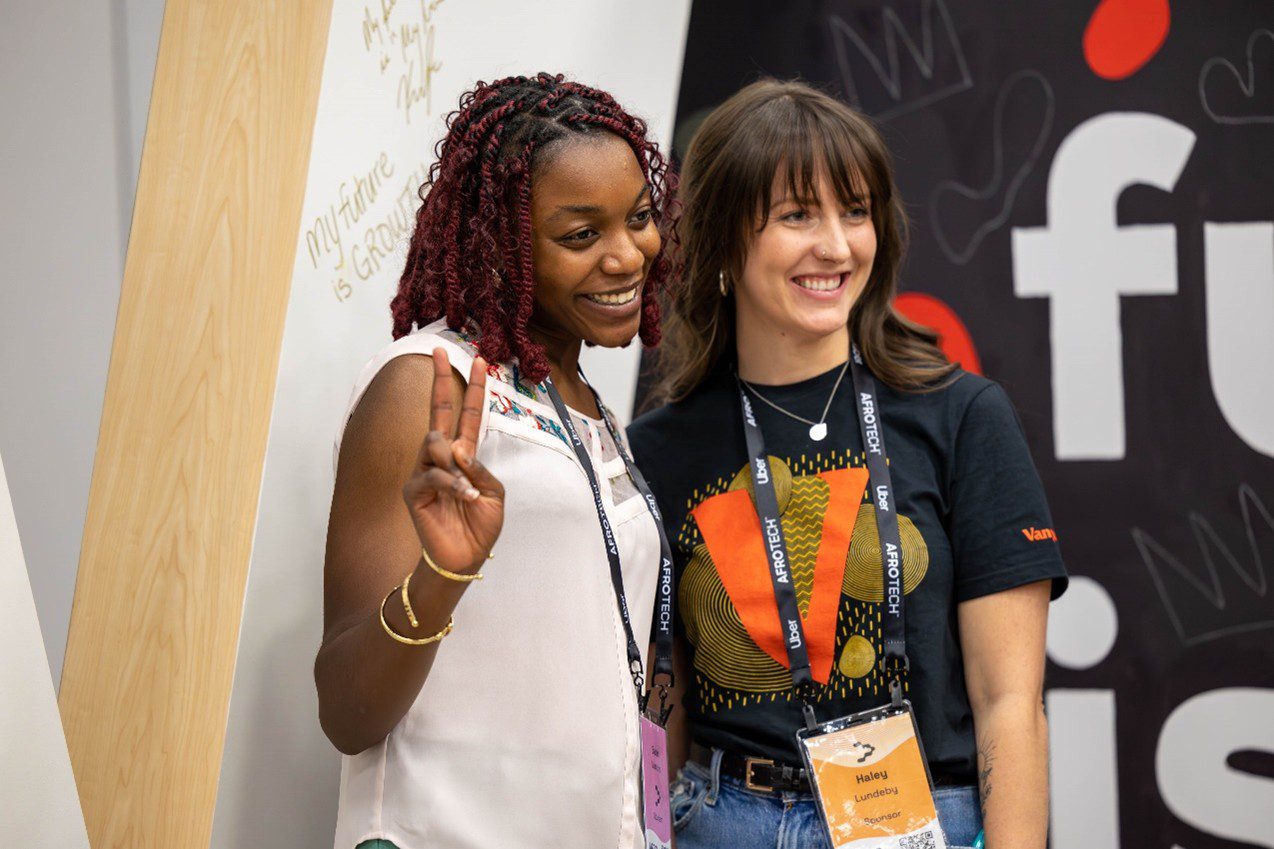 Haley L. smiling and posing with an attendee at the AfroTech conference