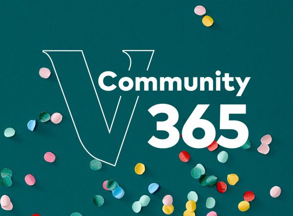 Teal background with scattered colorful confetti. A large white outlined 'V' is centered, with the word 'Community' and the number '365' in bold white text layered over it.
