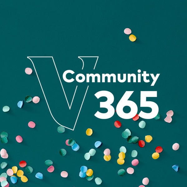 Teal background with scattered colorful confetti. A large white outlined 'V' is centered, with the word 'Community' and the number '365' in bold white text layered over it.