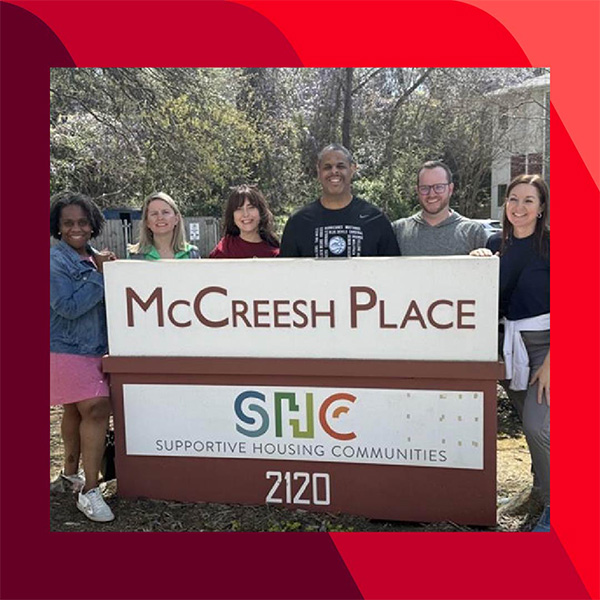 Haley and five other people stand behind a sign that reads 