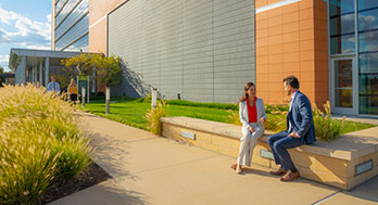 Two Edward Jones's workers sitting outside of Corporate south buiding