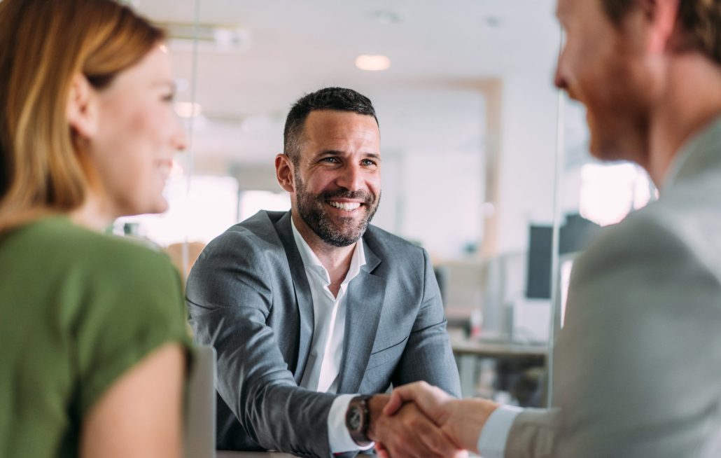 handshaking across the table during a meeting in modern office. 