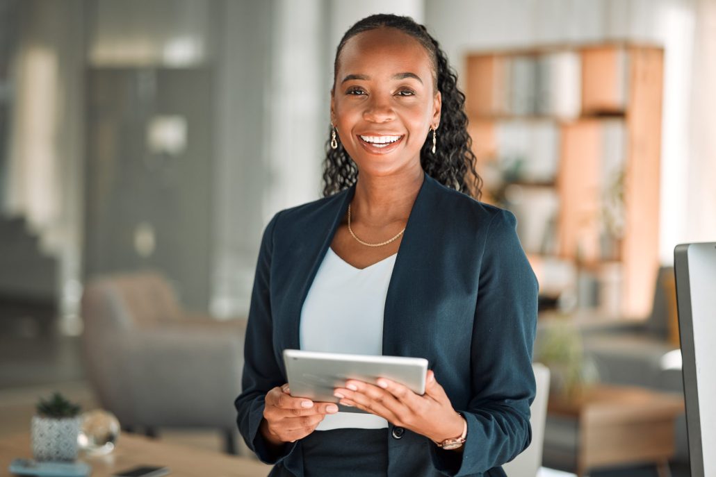 Financial Advisor smiling in an office, holding a tablet.