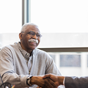 Two men shaking hands in office.