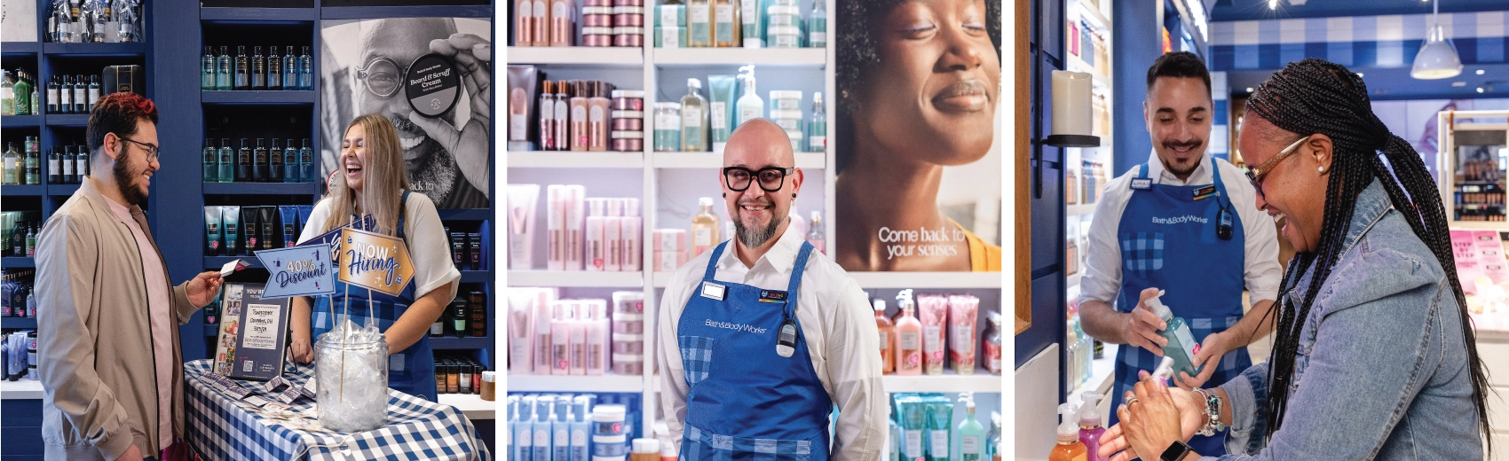 A Bath & Body Works associate in a blue gingham apron chats and smiles with a candidate at a now hiring display in-store. A Bath & Body Works associate smiles in front of a wall of products. A Bath & Body Works associate smiles and shows a customer hand soaps at the in-store sink.