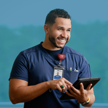 A smiling male nurse holding a tablet computer