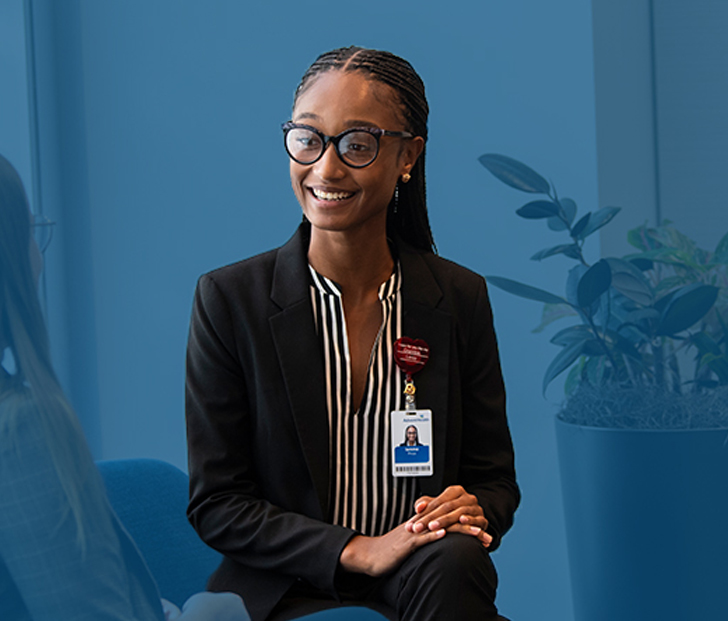 A smiling female business professional talking with another female business professional