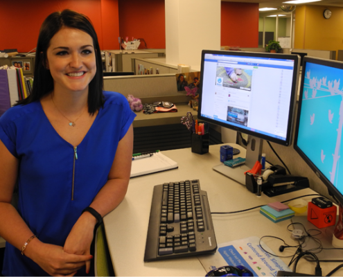Female Allstate Marketing professional at her desk, working on social media.